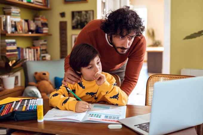 Father Helping His Son With homework at home