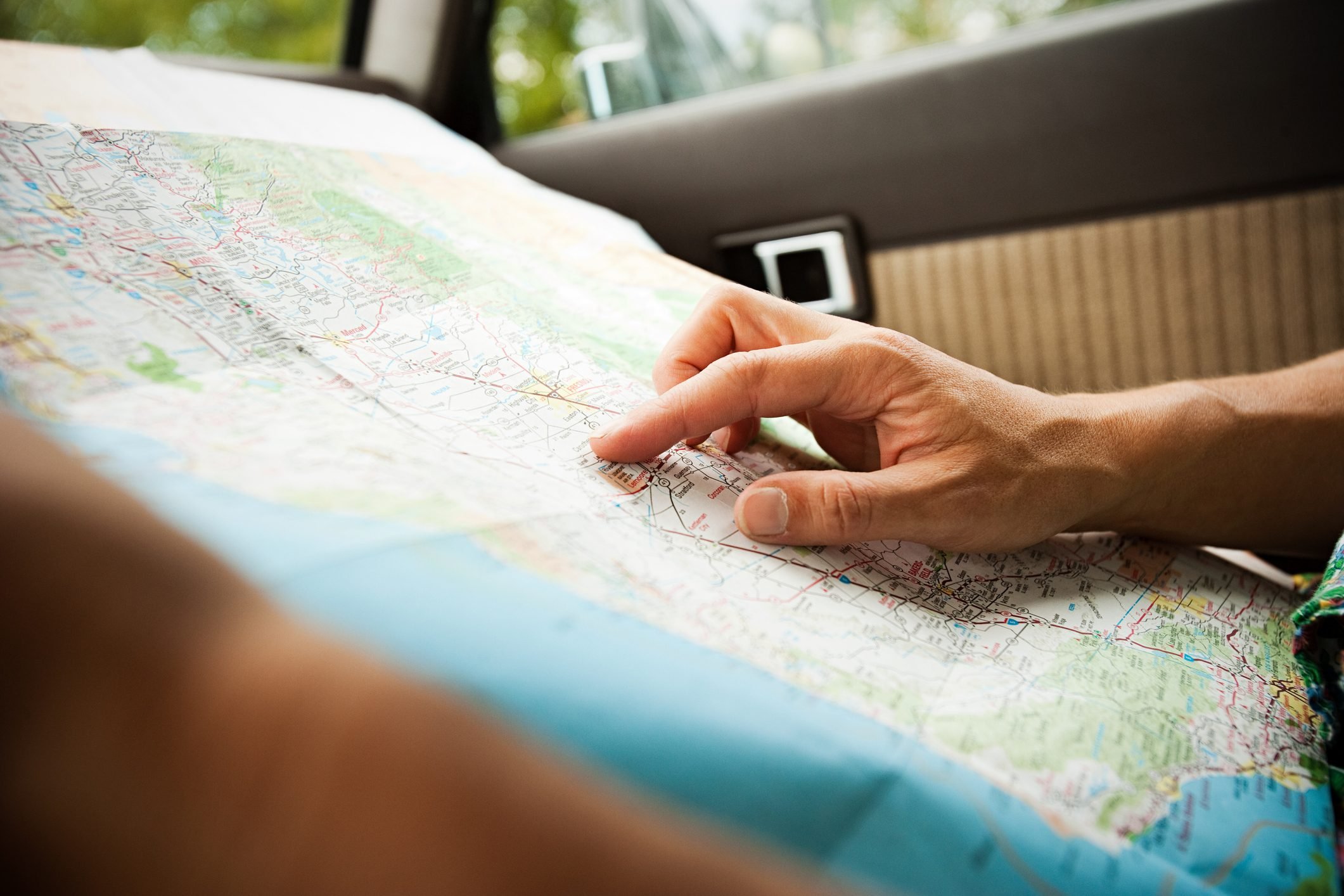 close up of hands examing a map in the car