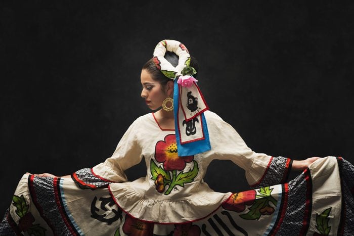 Hispanic teenage girl dancing in a Sinaloa Folkloric dress to celebrate hispanic heritage month