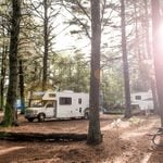 RV park with sun streaming through the trees
